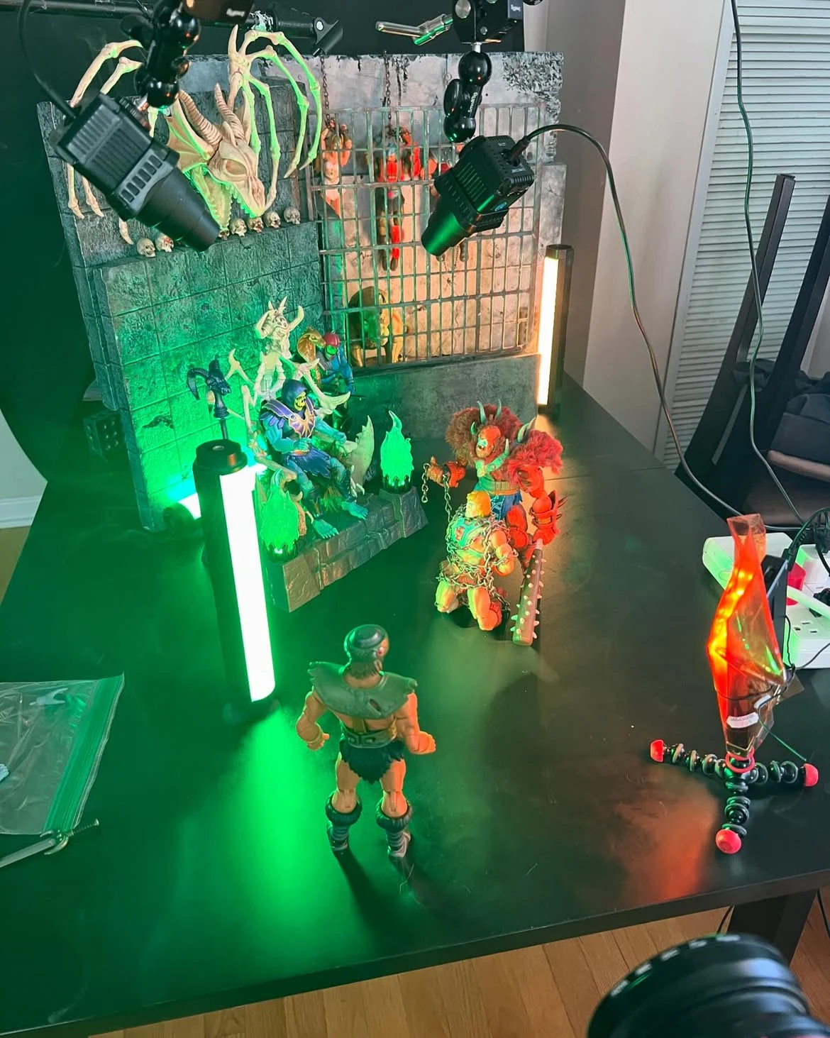 The dungeon set lit with a green tube light on a work table, figures posed in place