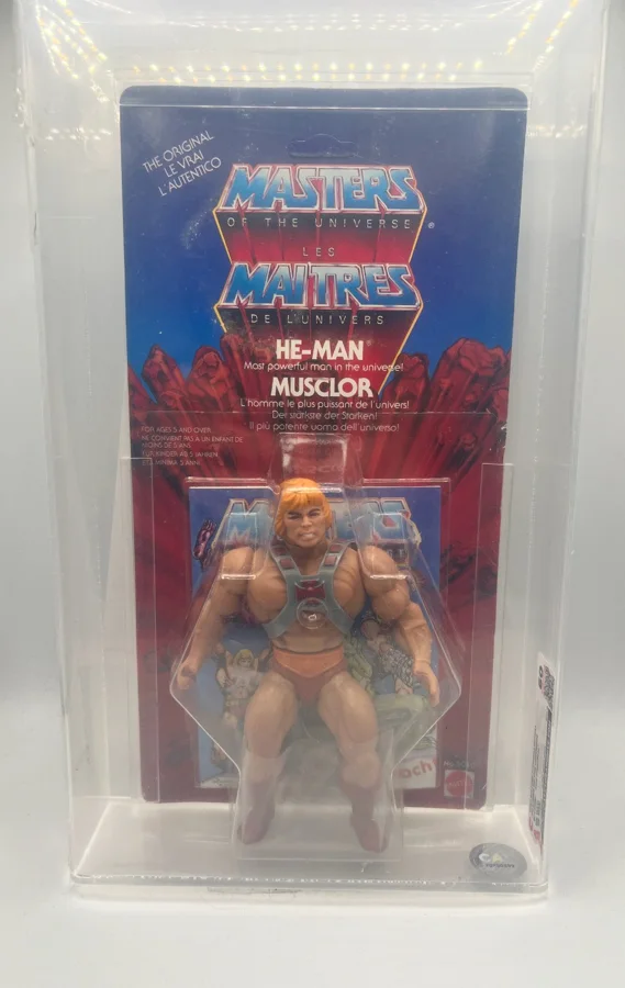 Carded 1983 Mattel Europe He-Man on a bilingual Masters of the Universe / Les Maitres de l'Univers card, in a CAS acrylic case