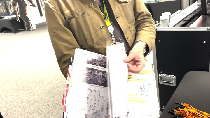 The reference book held open, flight case and marker pens on the desk beside it.
