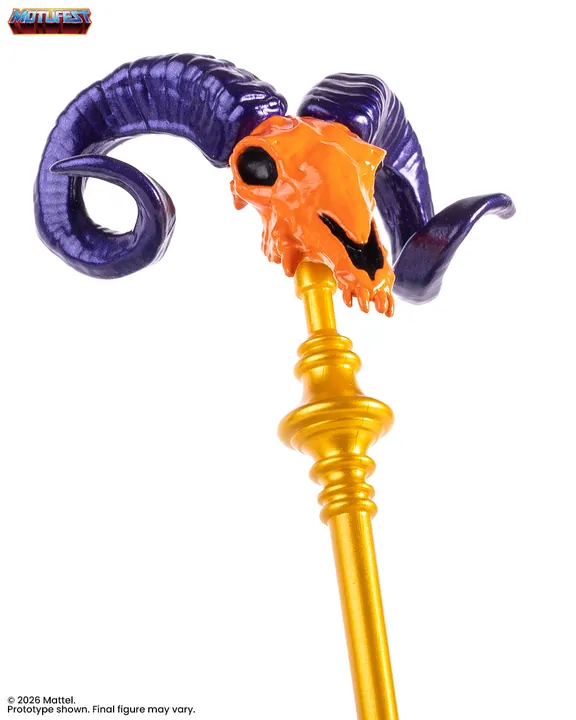 The head of the Havoc Staff in close up: an orange ram skull between two purple horns on a gold shaft.