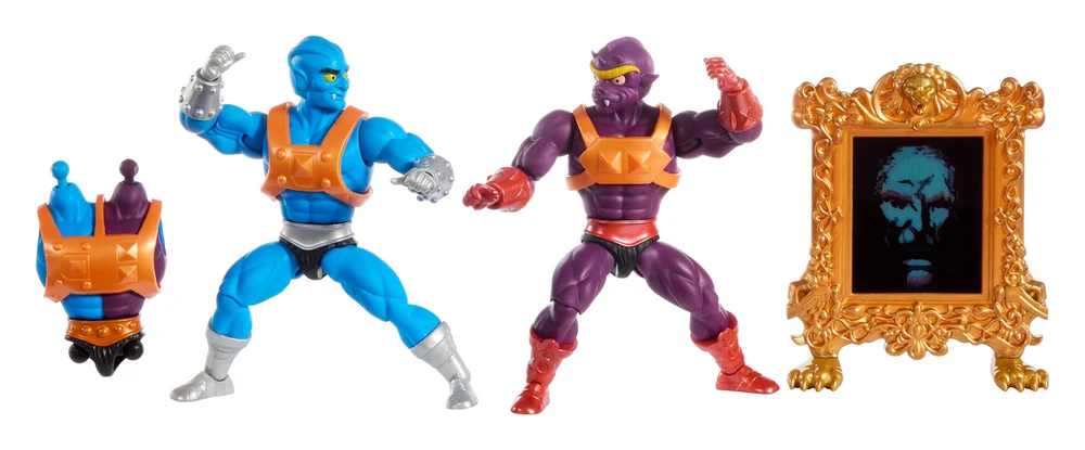 The contents of the Masters of the Universe Origins Two Bad Multipack laid out on white: a spare half blue, half purple torso in orange armour, the blue Tuvar figure with silver studded gauntlets, the purple Baddrah figure with red gauntlets, and the Mirror of Avathar in a gold frame.