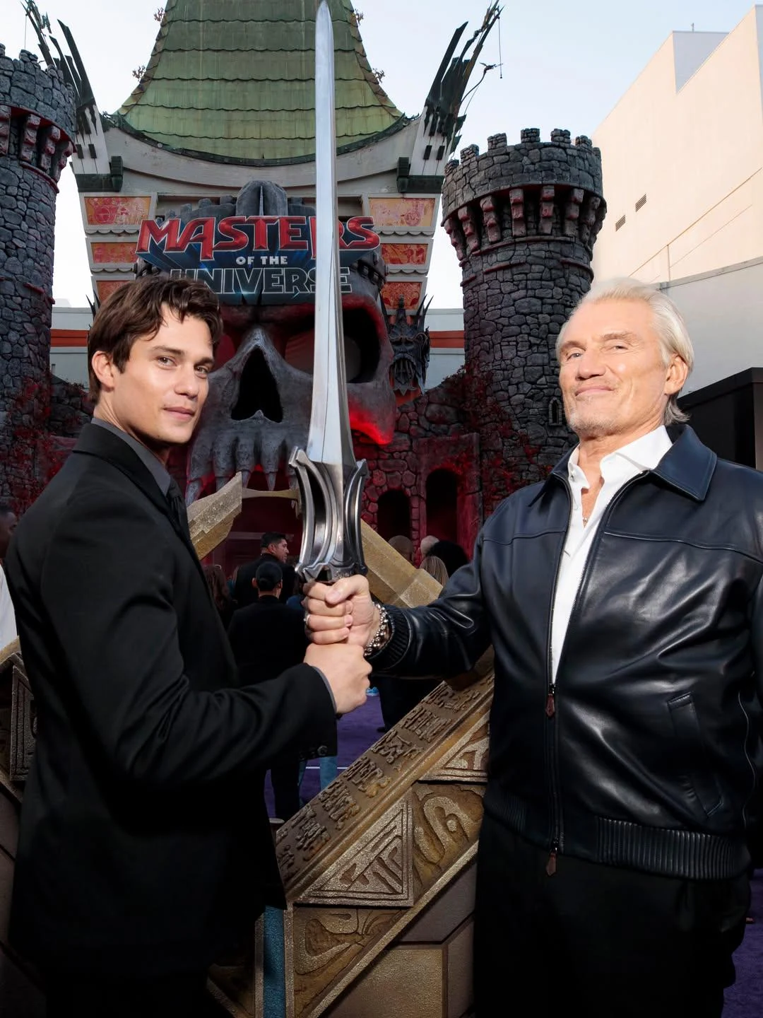 Dolph Lundgren hands the Power Sword to Nicholas Galitzine.