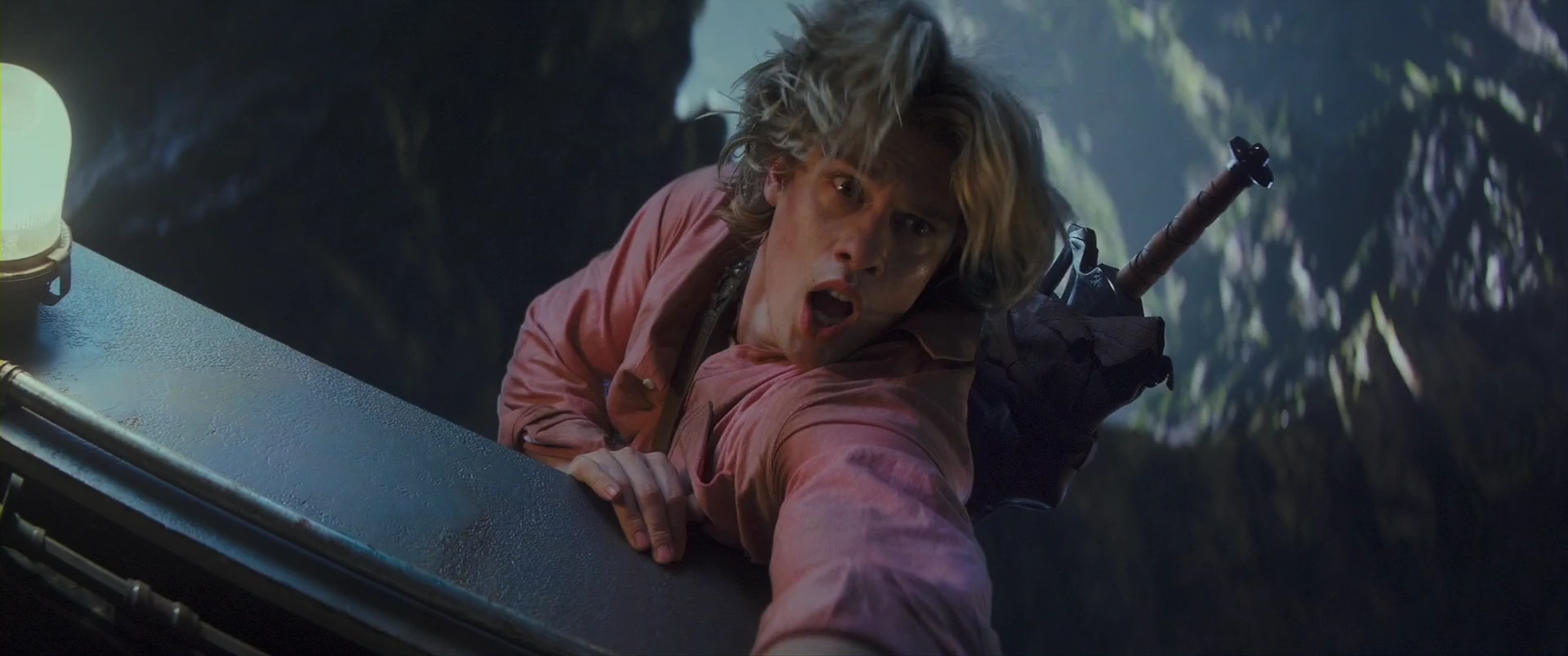Adam clings to a gangway high above the canyon as the battle rages.