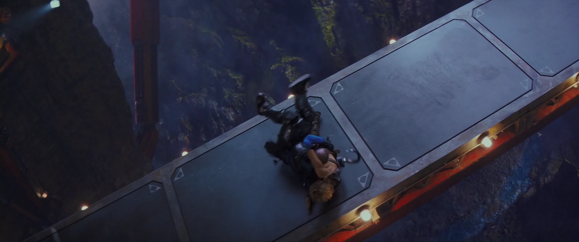 Adam and a pursuer grapple on a tilting gantry above the abyss.