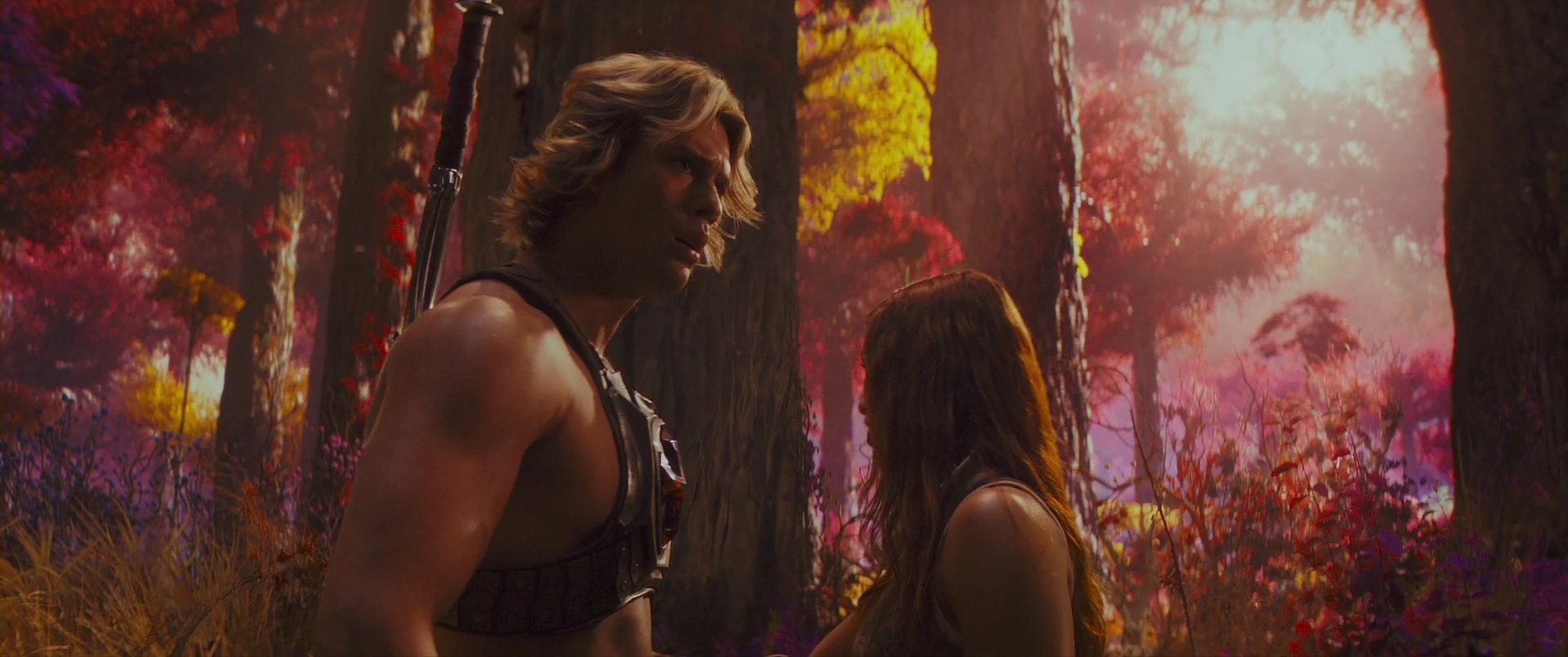 Adam, the Power Sword on his back, with Teela in the Eternian forest.