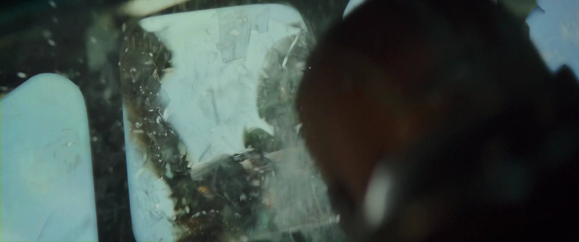 A survivor watches the battle through a shattered windshield.