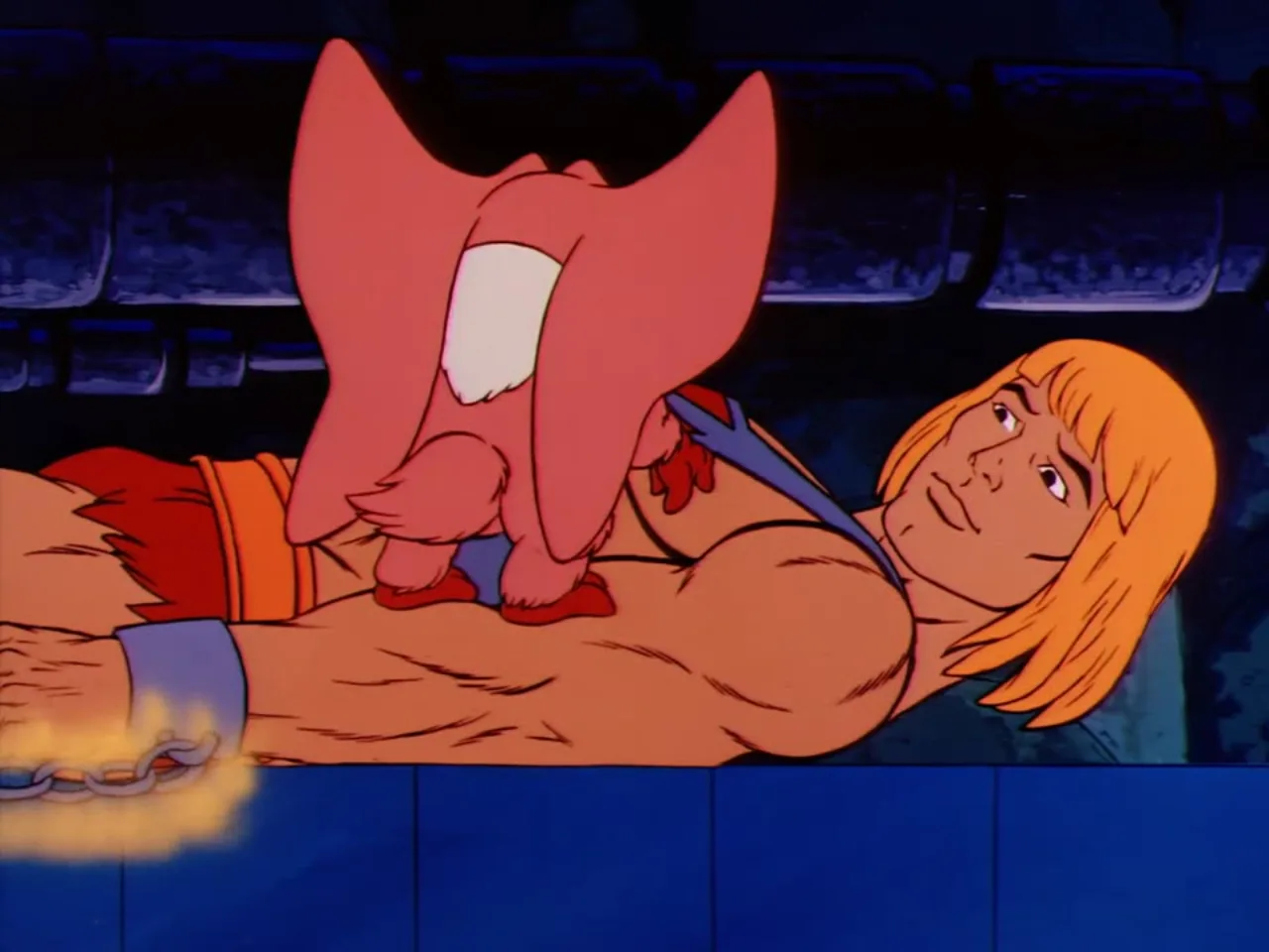Kowl sits close up with wings folded atop the chained Prince Adam