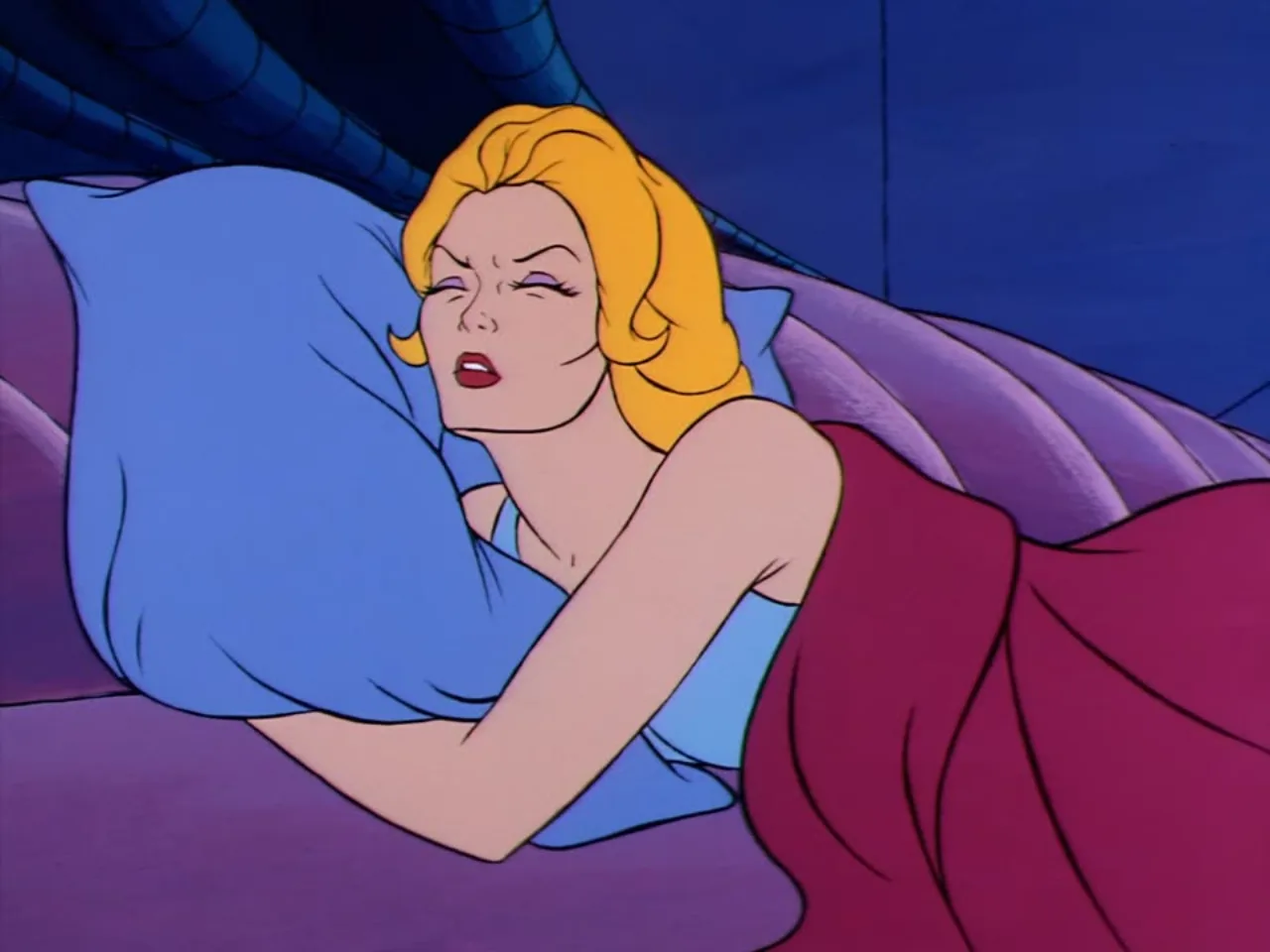 Adora sleeps fitfully on a blue pillow, her face tense as if troubled by a dream.
