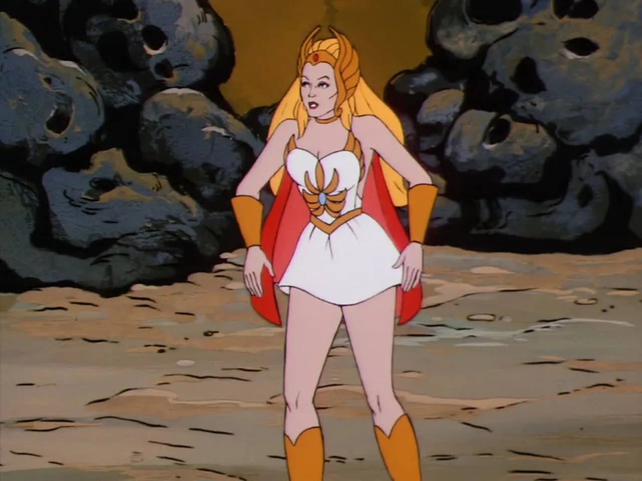 She-Ra stands alone on a barren shoreline flanked by skull-shaped boulders.