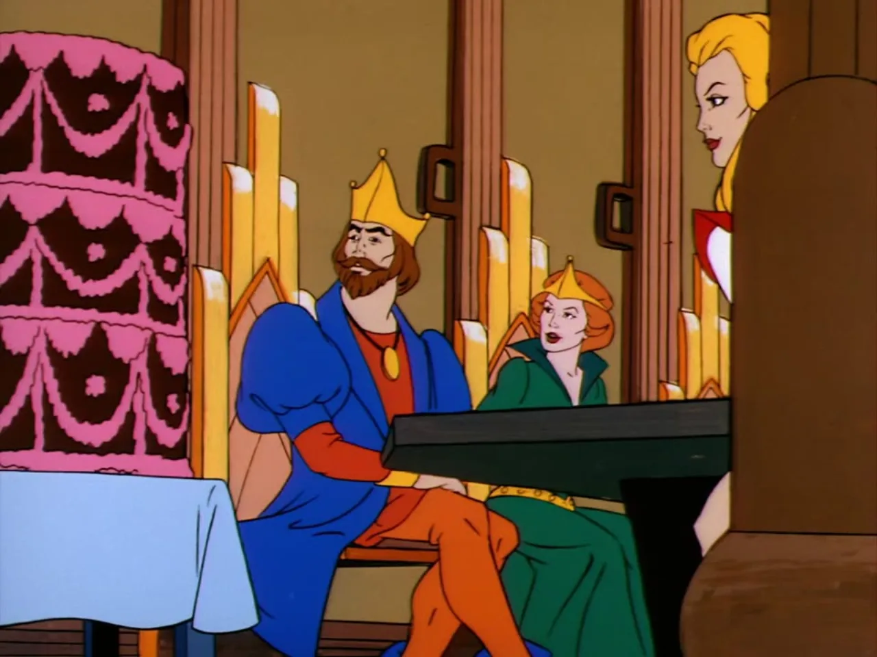 King Randor and Queen Marlena sit at a table beside a large pink cake while Adora looks on from the side.