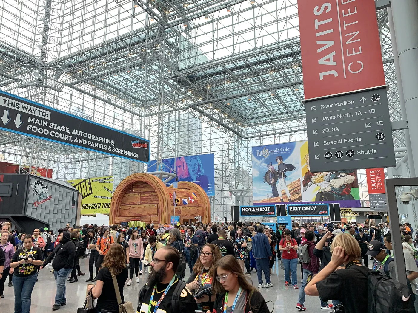 Attendees in the Javits Center atrium at New York Comic Con 2021 beneath a Javits Center banner