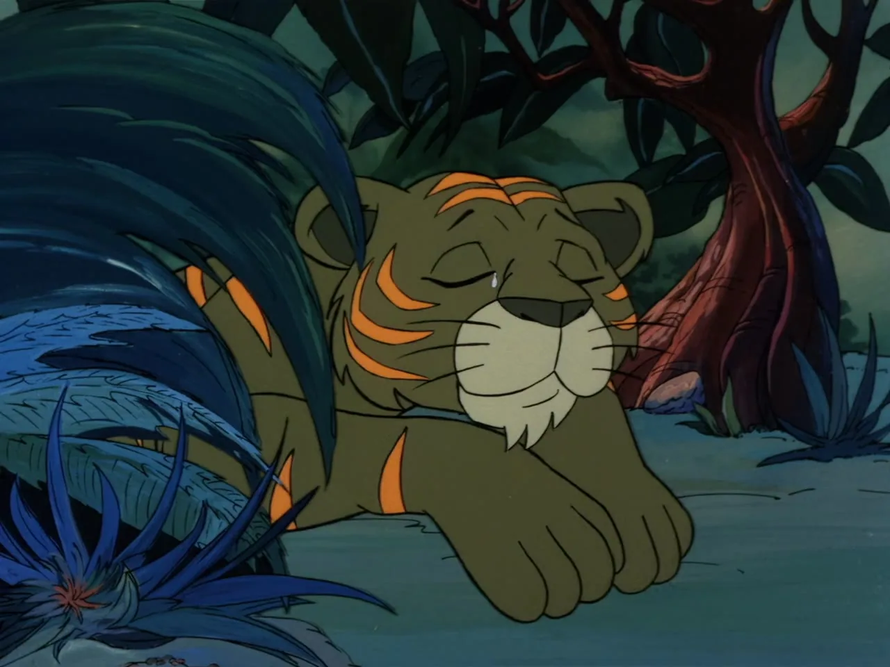 A small green tiger cub with orange stripes lies still on the jungle floor, eyes shut, a tear visible.