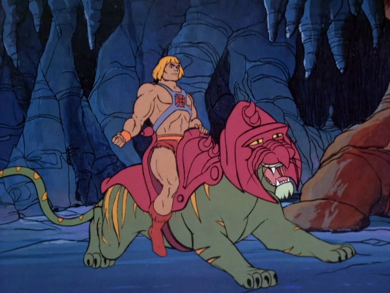He-Man rides Battle Cat at a prowling crouch through the cavern, Battle Cat's red helmet clearly visible.