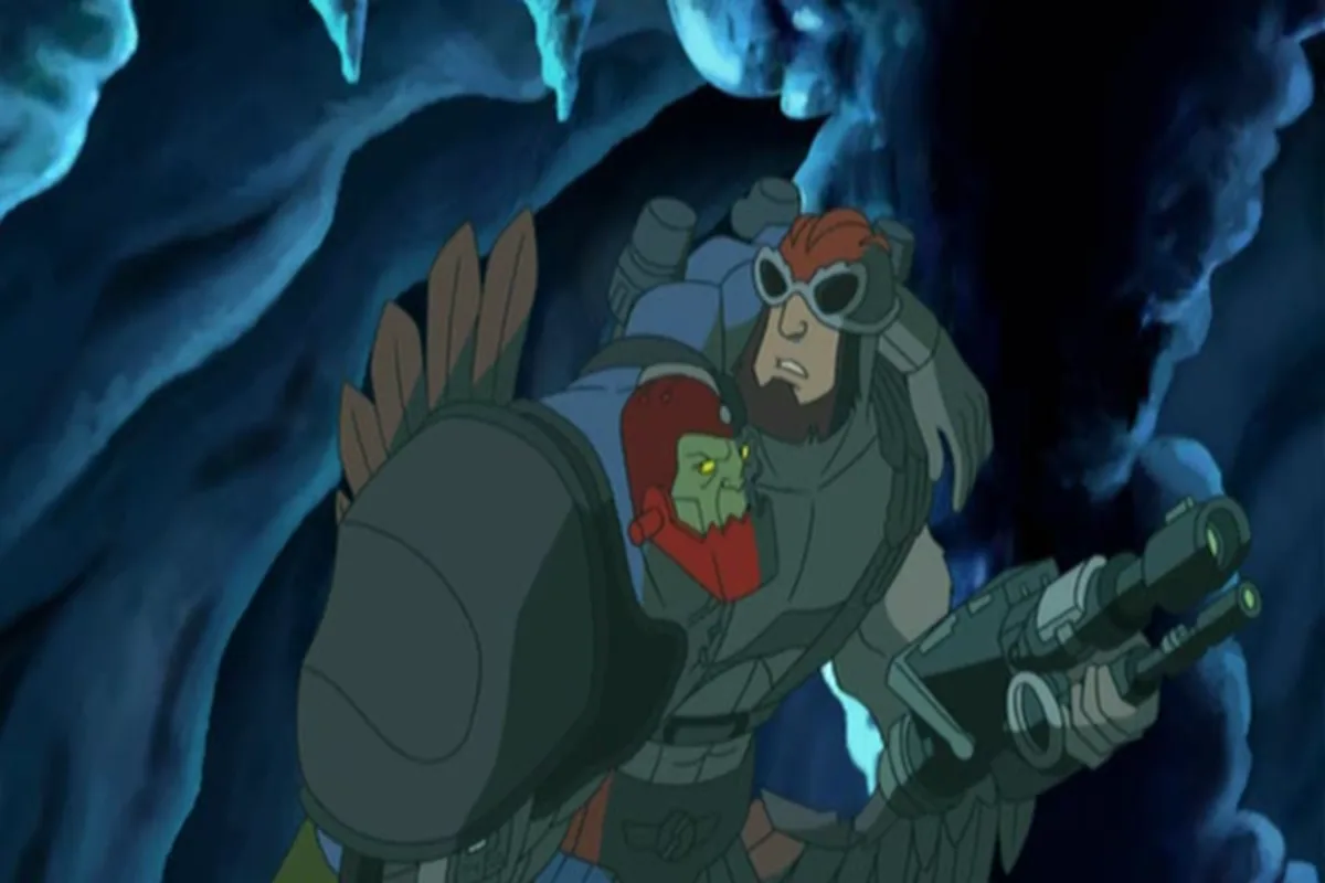Stratos carries Trap Jaw on his back through the dark cave, a cannon in his hand